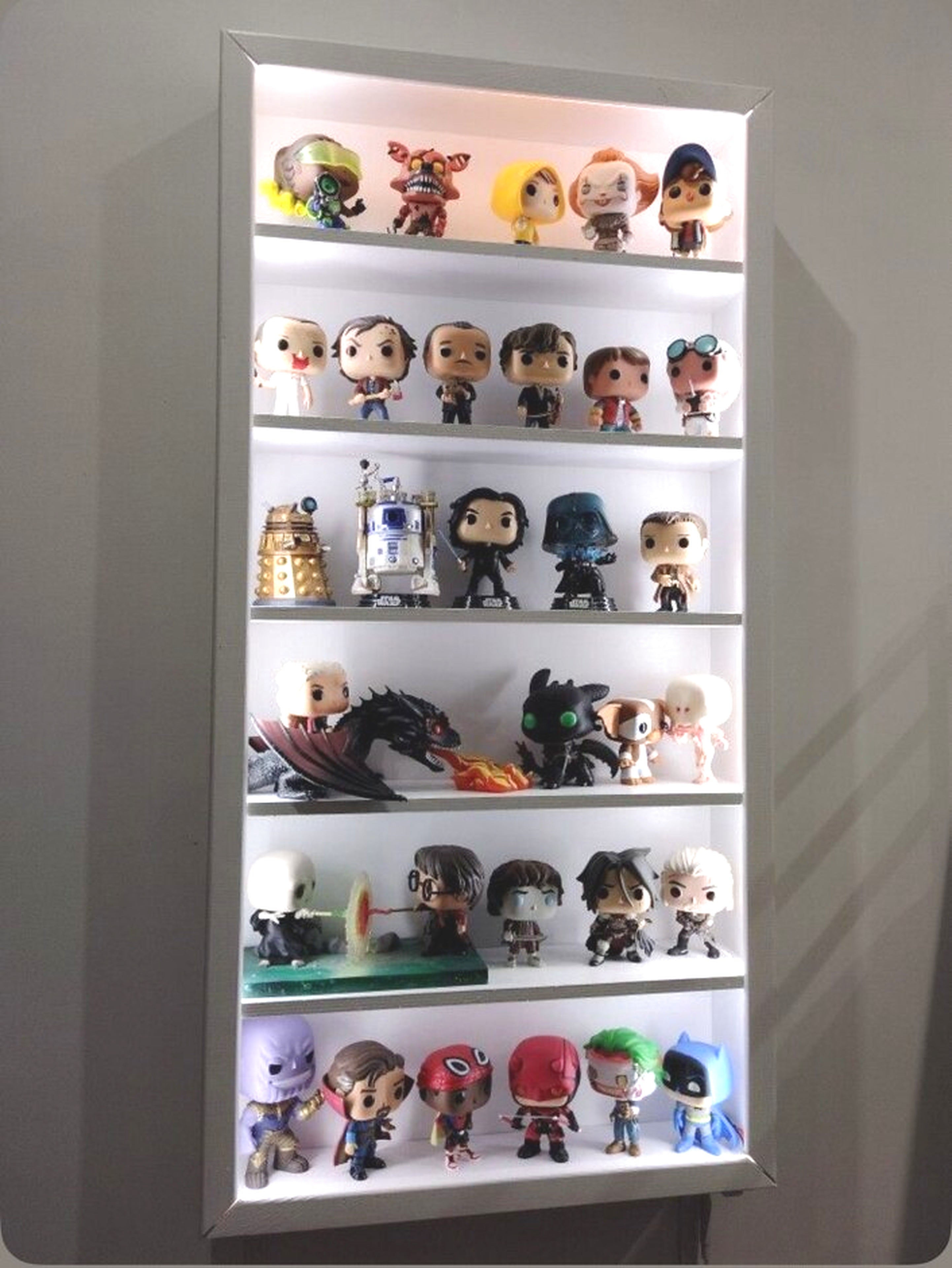 Funkos exhibidos en repisas iluminadas